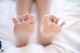 A close up of a person's feet on a bed.