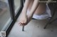 A woman sitting on a chair with her feet up on a window sill.