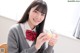 A young woman in a school uniform holding a jar of candy.