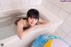 A woman laying in a bathtub with a beach ball.