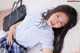 A young woman in a school uniform laying on a bed.