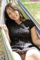 A woman in a black and white polka dot dress sitting in a hammock.