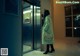 A woman standing in front of an elevator at night.