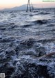 A person swimming in the ocean at sunset. 
