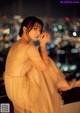 A woman in a yellow dress sitting on a ledge.