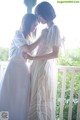 A couple of women standing next to each other on a porch.